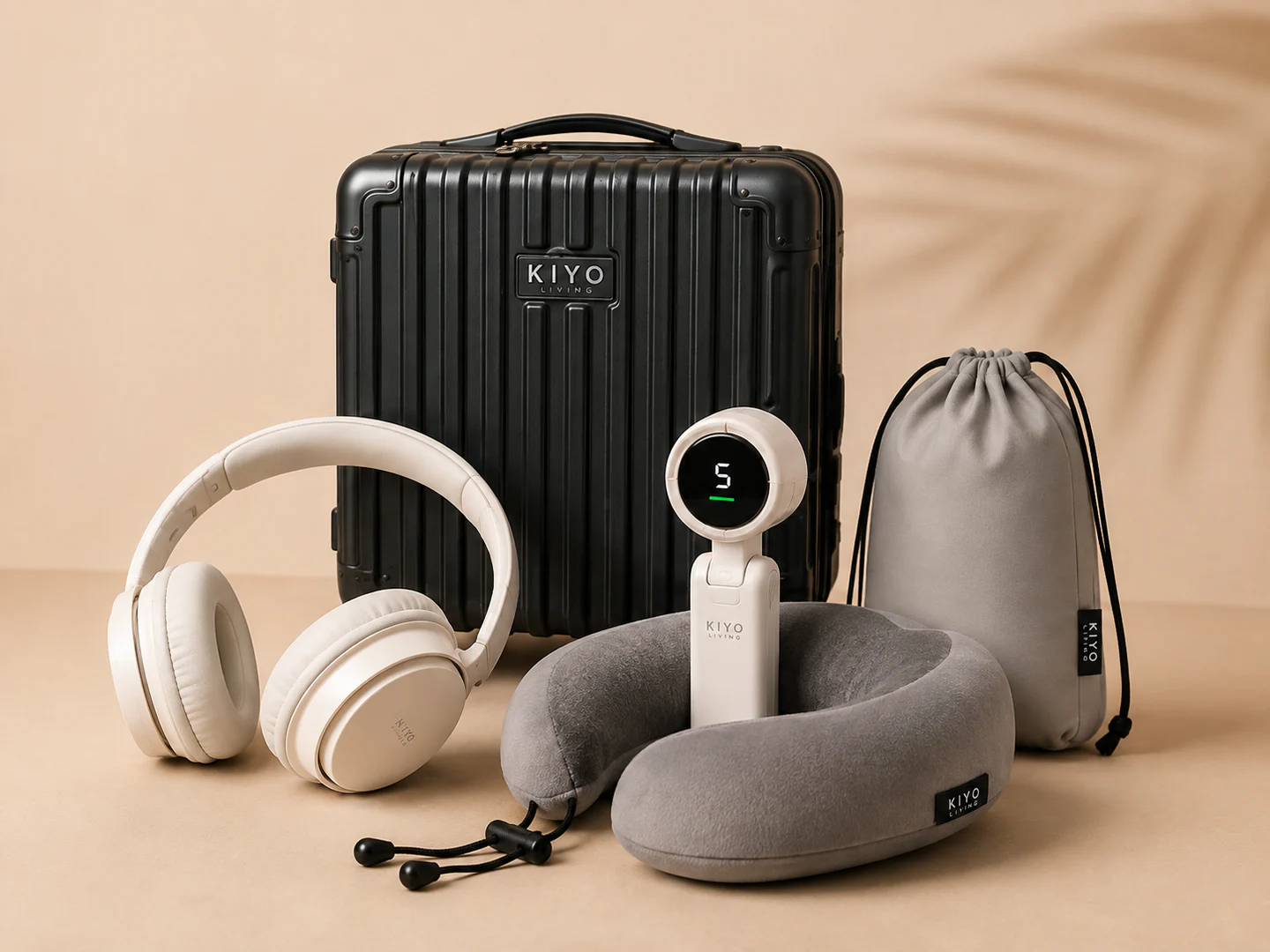 Black compact luggage with headphones, neck pillow, portable fan and travel pouch